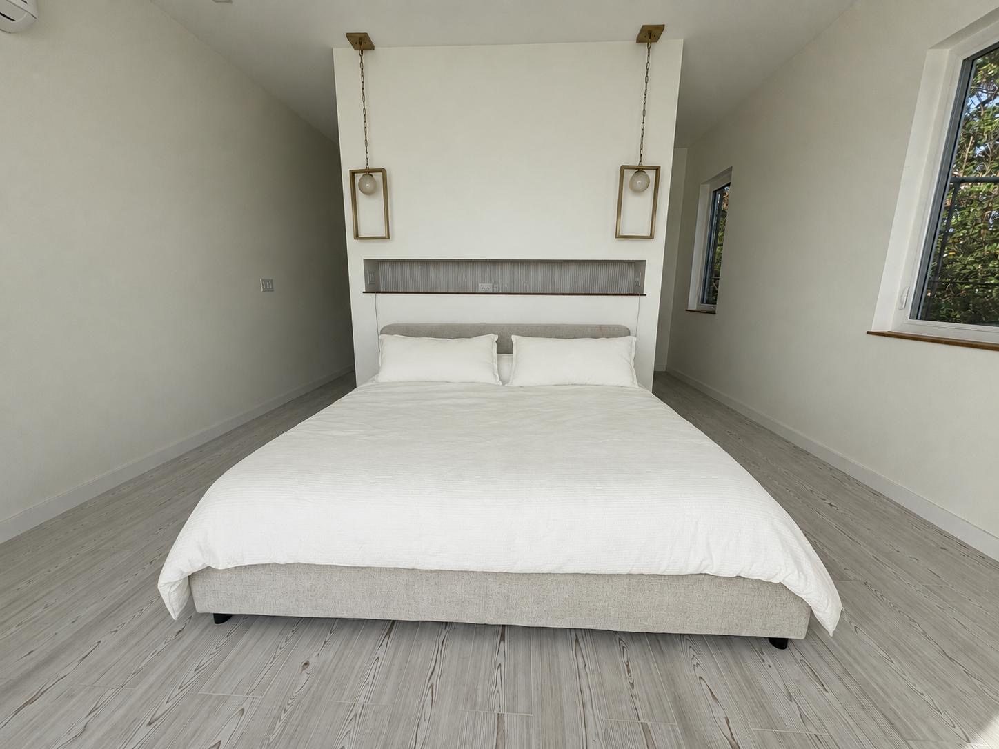 Bedroom with king bed and brass pendant lights