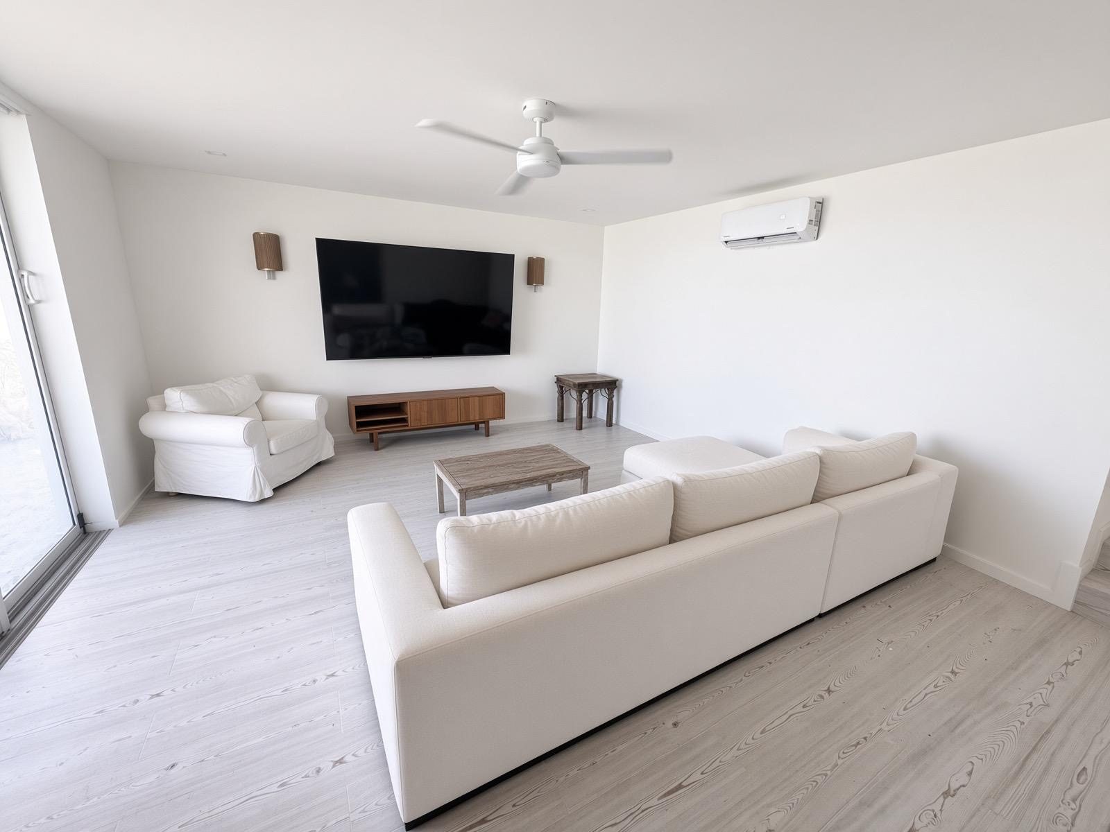 TV den with sectional sofa, wall mounted television and split unit air conditioning
