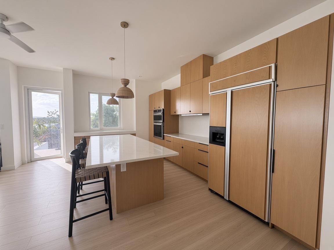 Kitchen with island seating, double wall ovens and panelled fridge